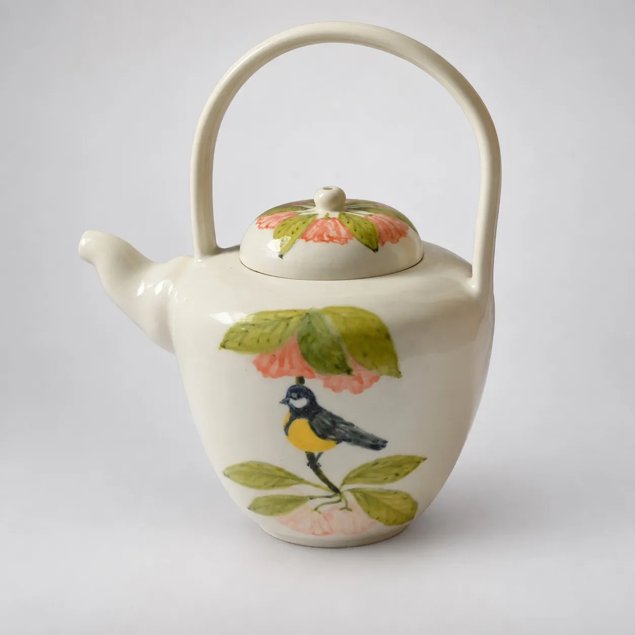 The teapot from the other side, spout to the right, the painted bird and blossoms wrapping the body