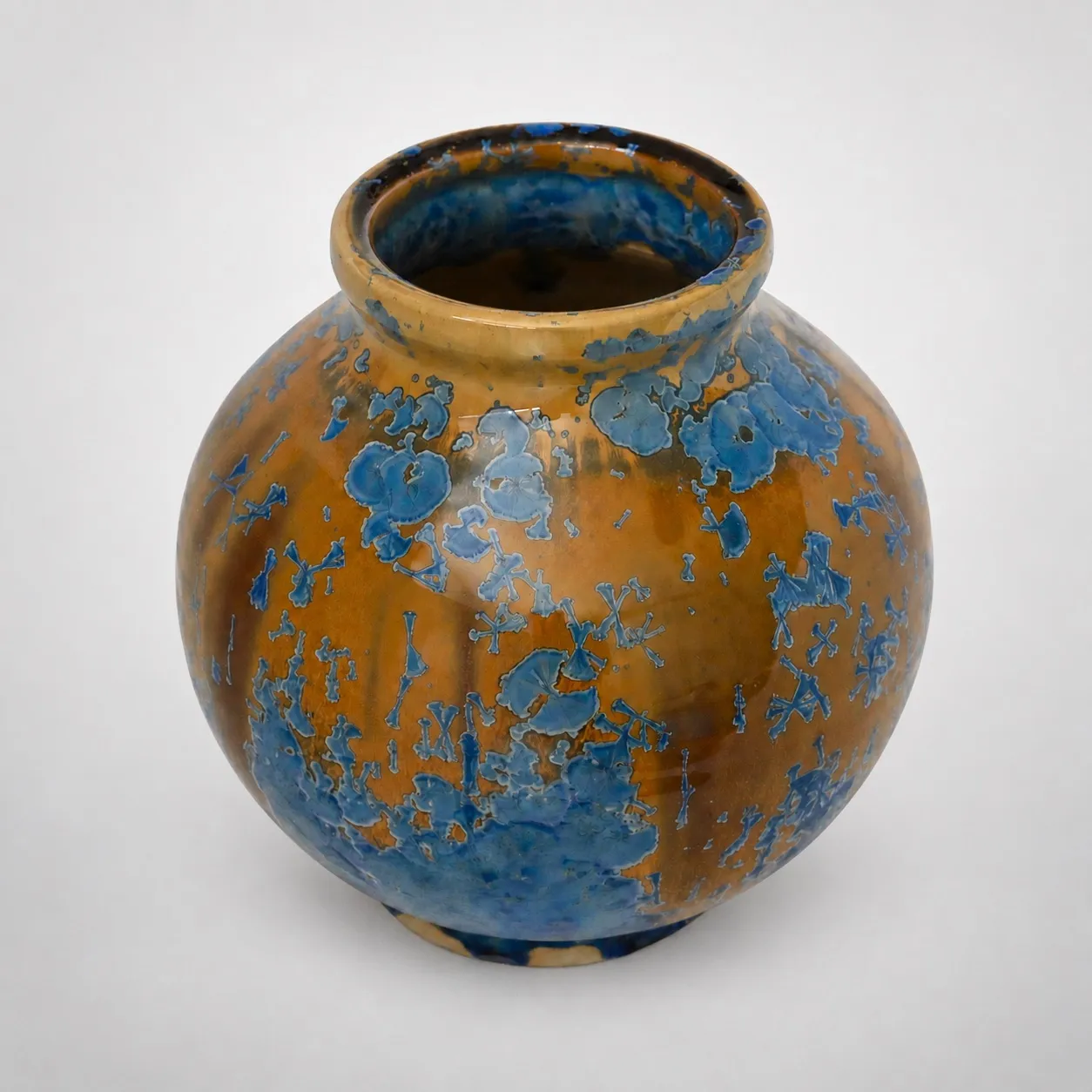 A round stoneware vase, ochre ground densely covered with bright light-blue crystal blooms